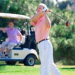 playing golf on course with man driving ball from tee
