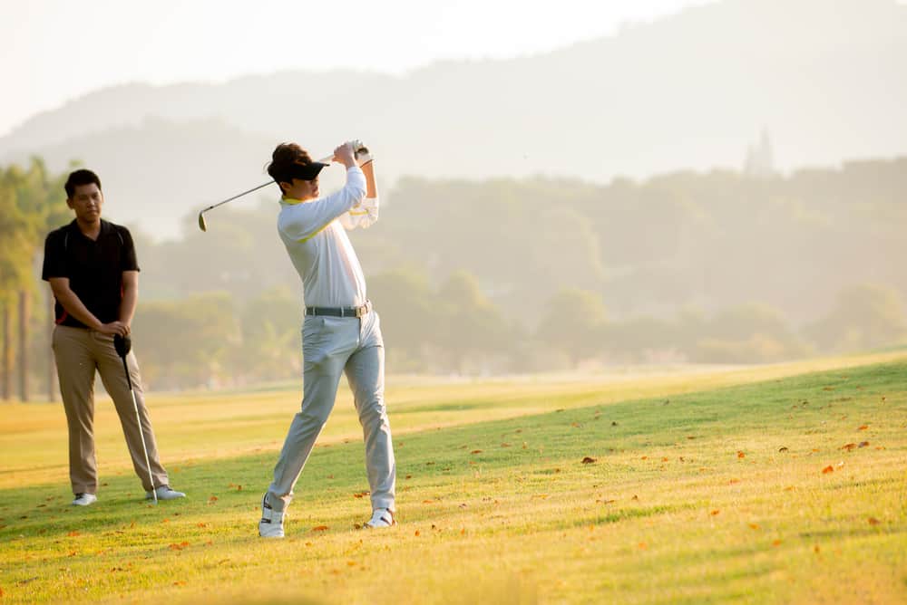 man golfer playing golf with friend at golf course