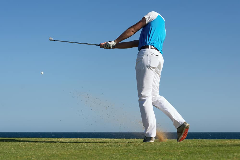 Golfer hitting ball with force