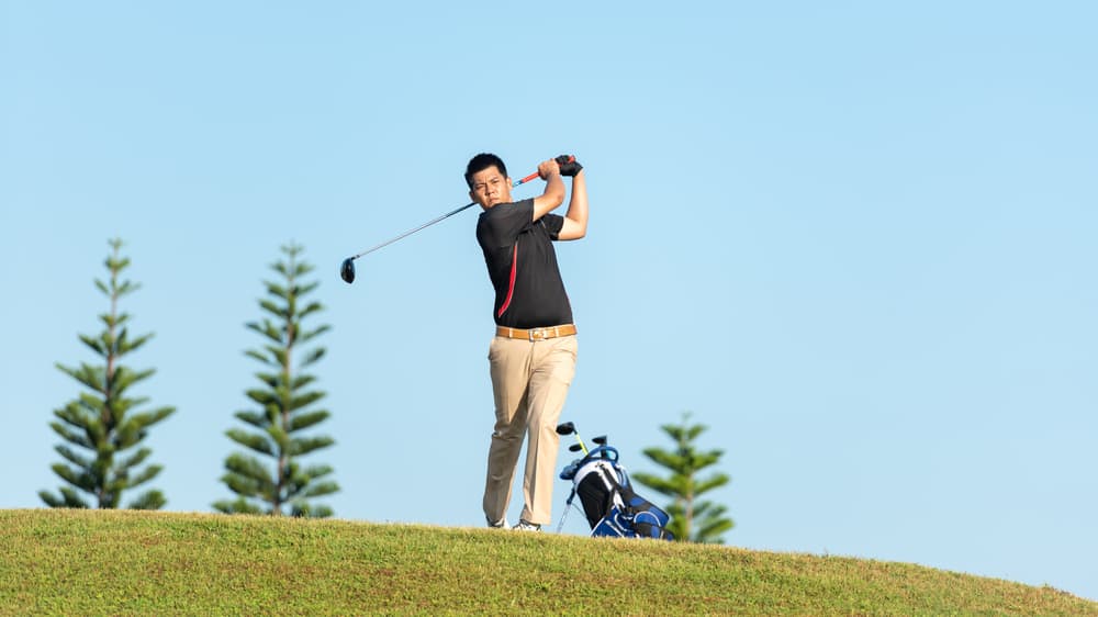 man approach on tee off for swing and hitting golf ball