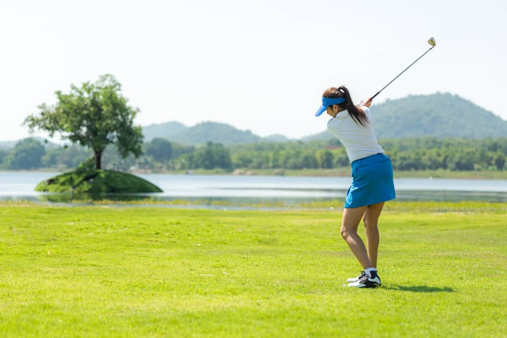 woman playing game golf and hitting go on green