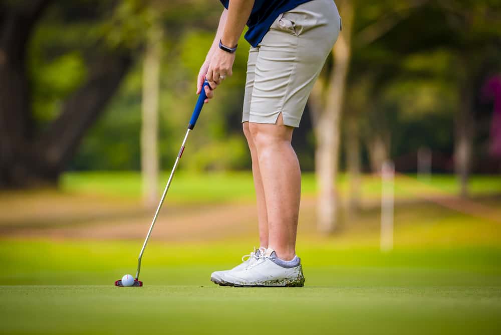 Golfer is teeing off golf ball by golf club