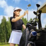 Professional woman golf player choosing the golf club