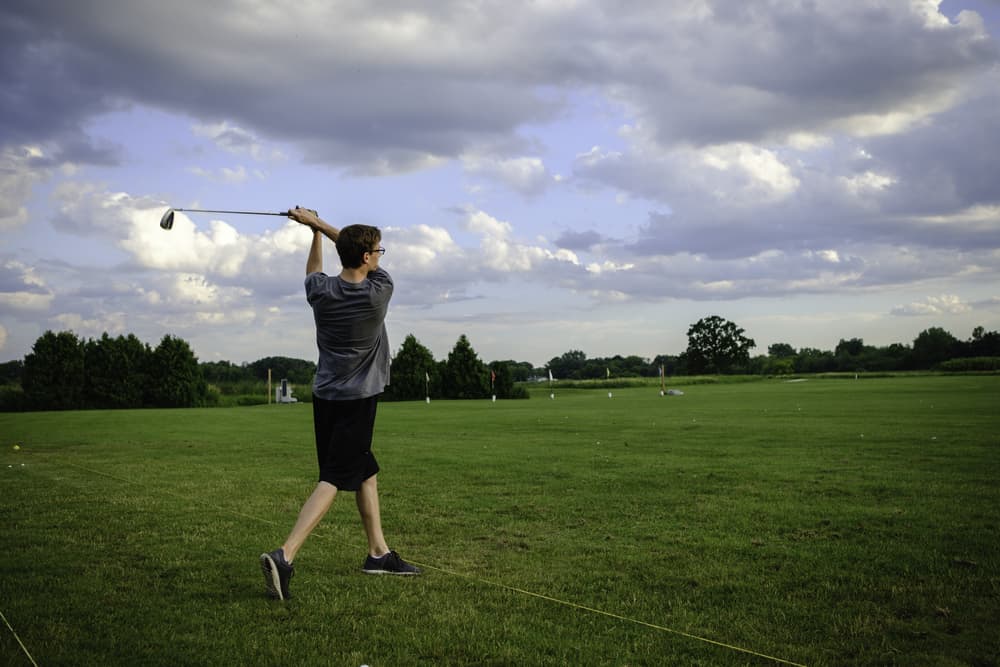 Teen after his golf swing at the driving range