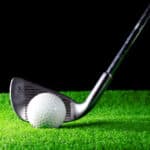golf iron and golf ball on green grass