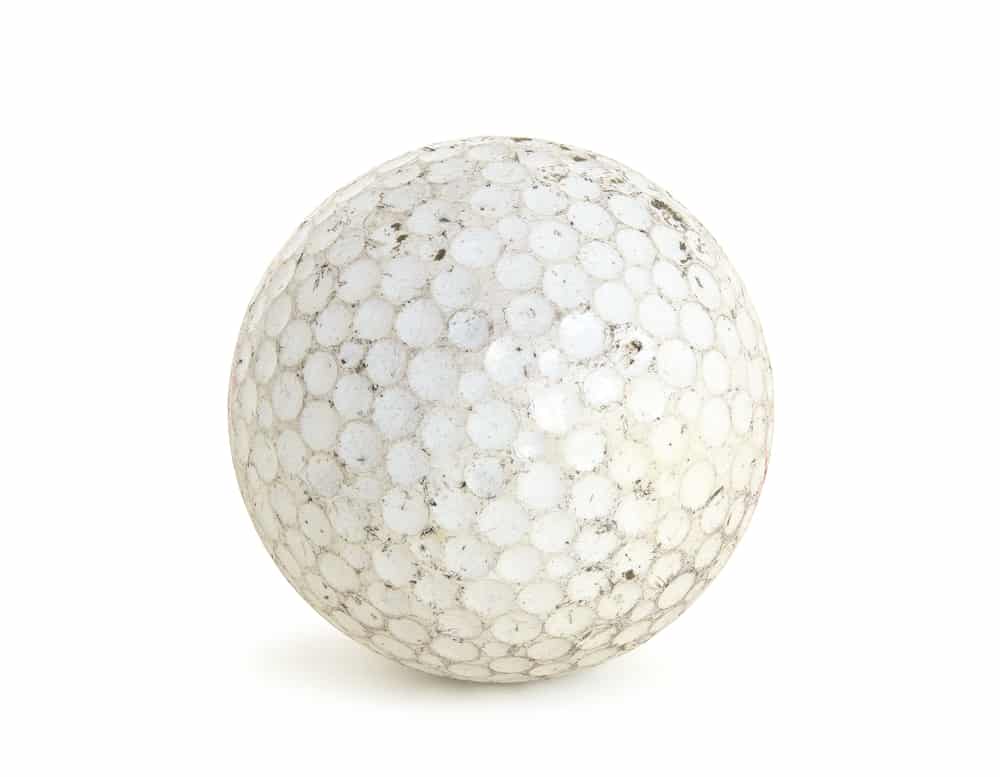 Dirty golf ball isolated on white background