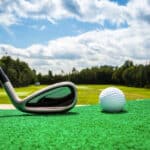 Close-up of a golf ball and a golf iron on a driving range
