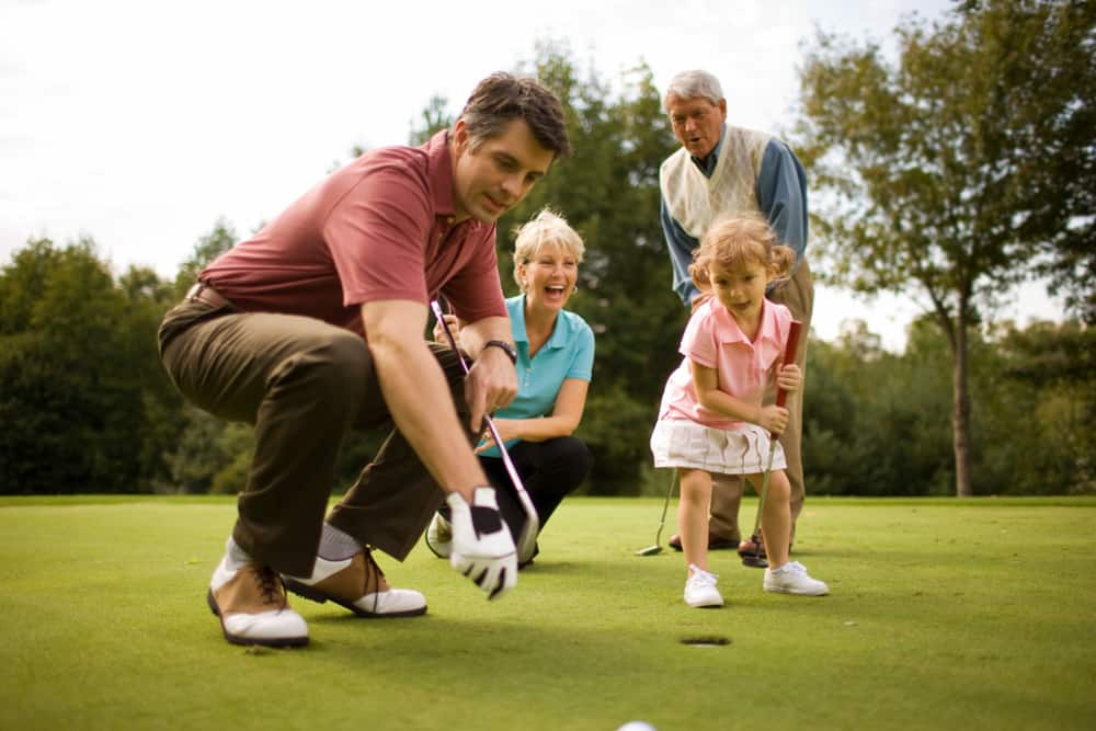 Family playing golf together on a golfing green