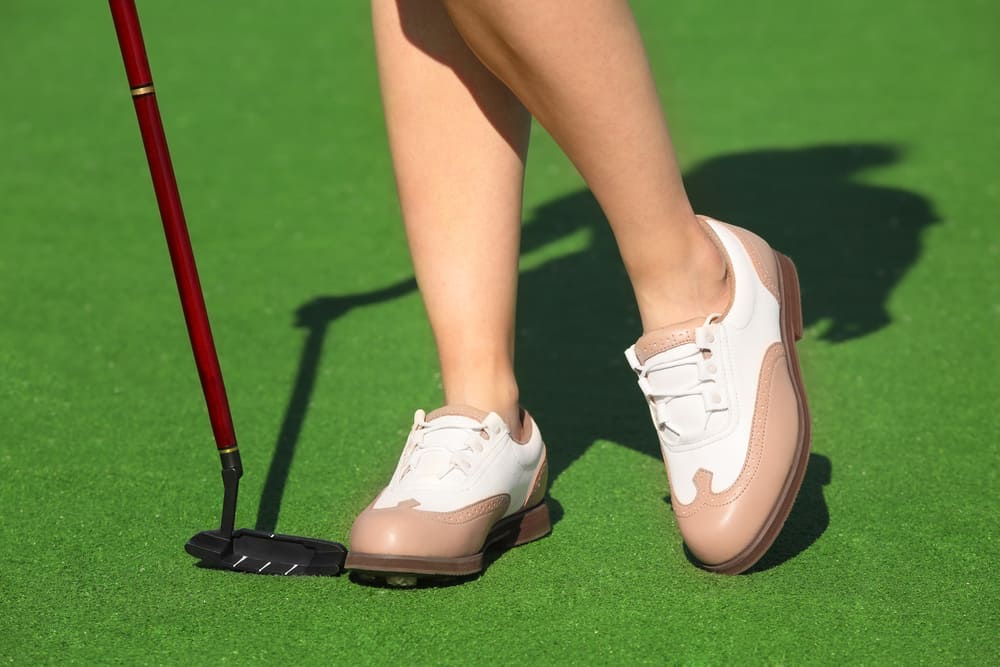 Female golf player at course in sunny day