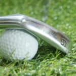 Golf iron and ball on green grass - iron 9