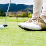 Golf player hitting a ball at the putting green