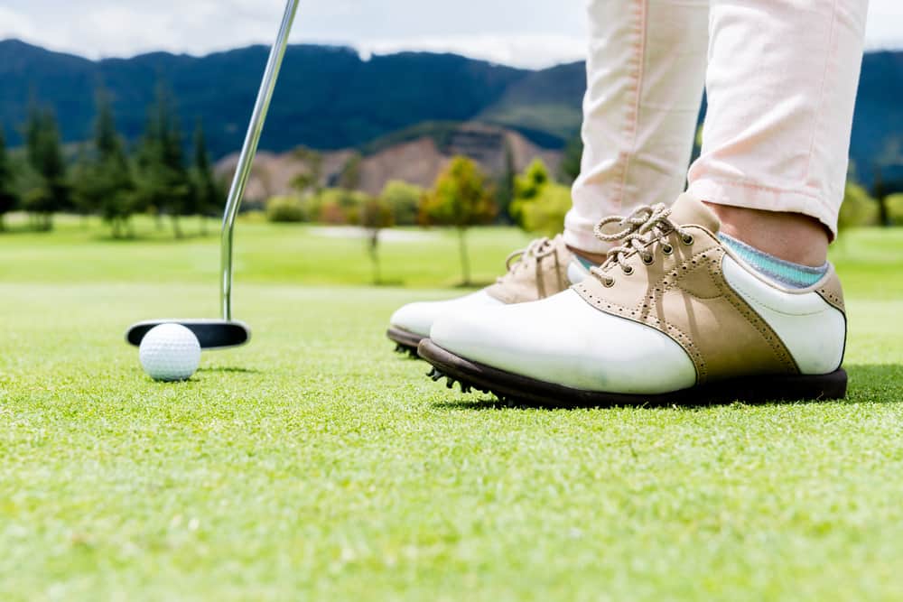 Golf player hitting a ball at the putting green