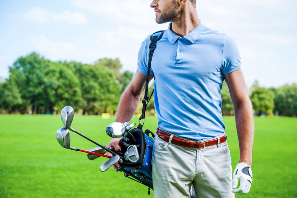 Golfer carrying golf bag