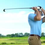 Male golfer hitting ball performing draw position