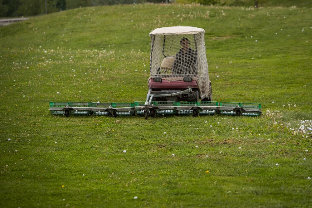 golf cart with a rack to collect golf balls on a driving range of a golf course