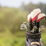 Golf clubs drivers over green field background