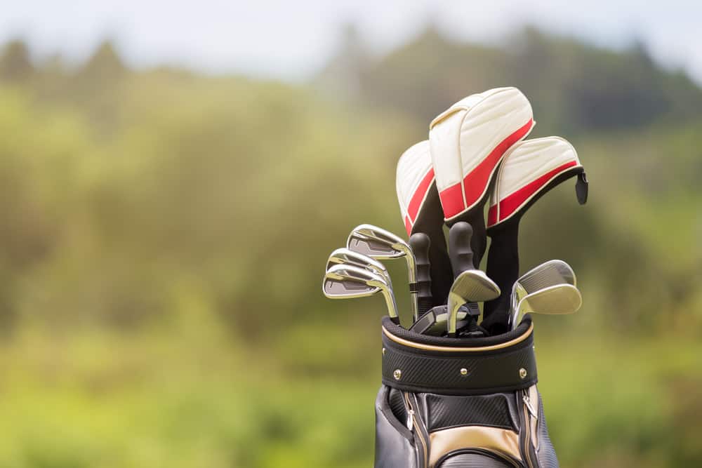 Golf clubs drivers over green field background