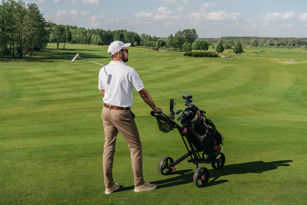 Golf player standing on green pitch