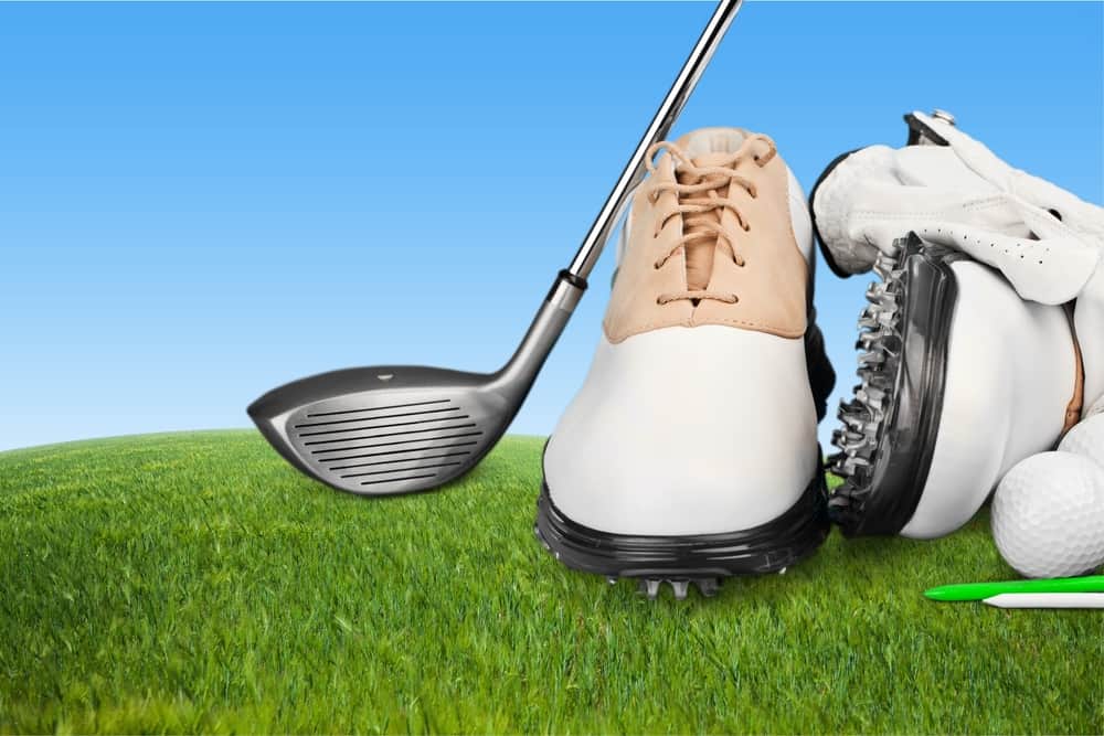 Pair of golfing shoes and a golf club