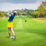 golfer is teeing off golf ball by golf club