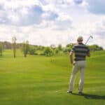 male golfer standing at fairway on golf course