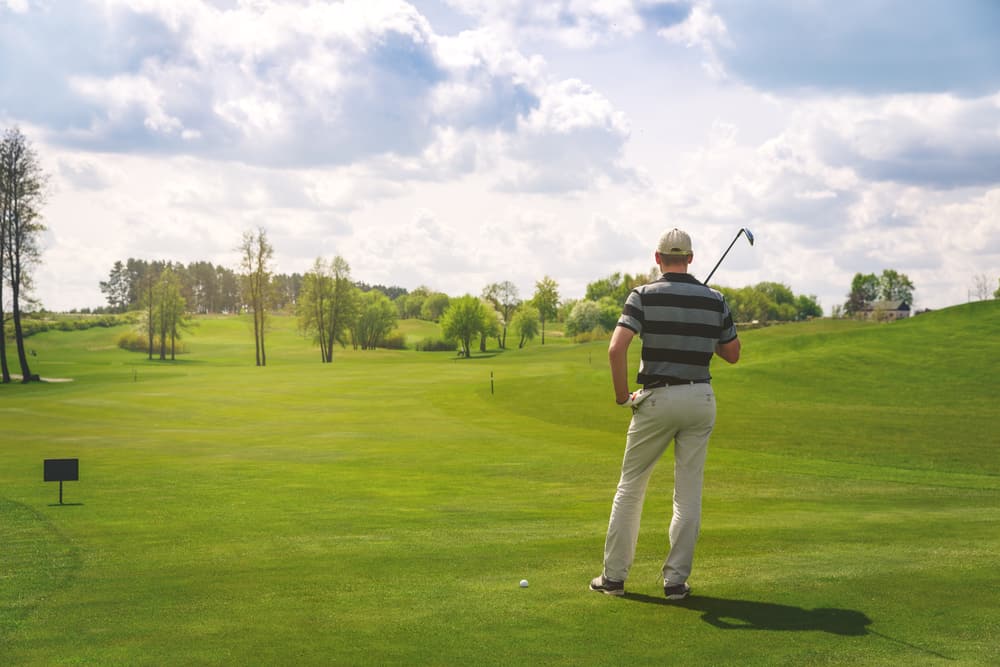 male golfer standing at fairway on golf course