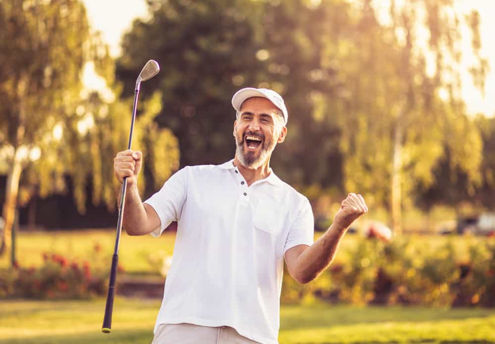 Happy successful man on golf field