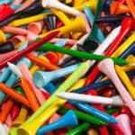 Various wooden golf tees in a box