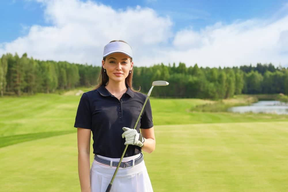 woman standing with golf club in golf course