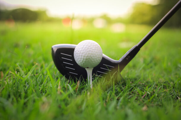 Golf club and ball in green grass